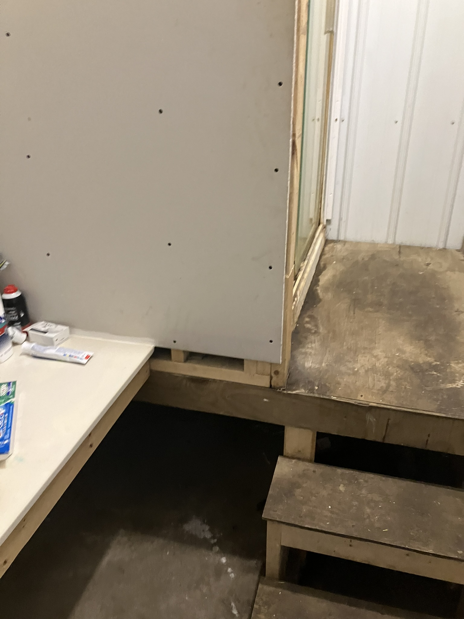 photo of unfinished drywall and plywood stairs